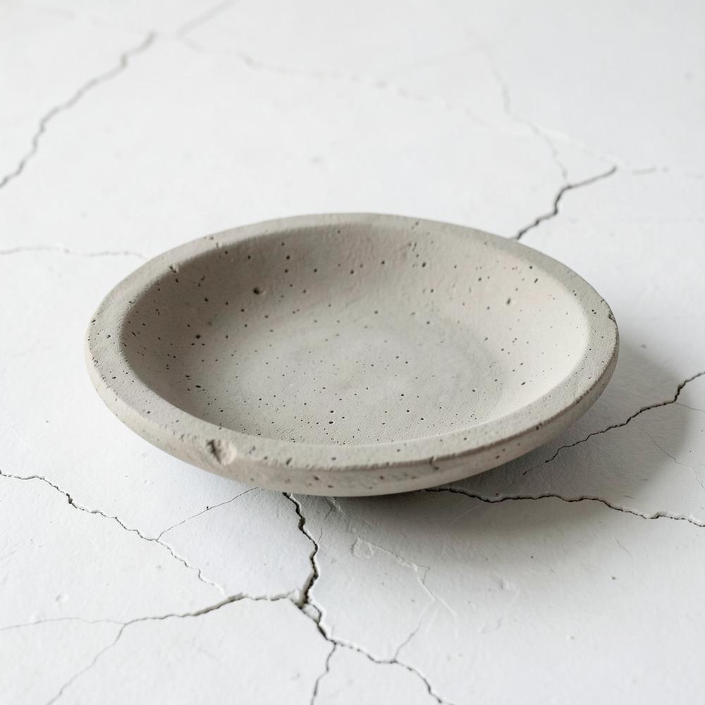Coupe basse en terre non émaillée, surface mate, lumière douce.